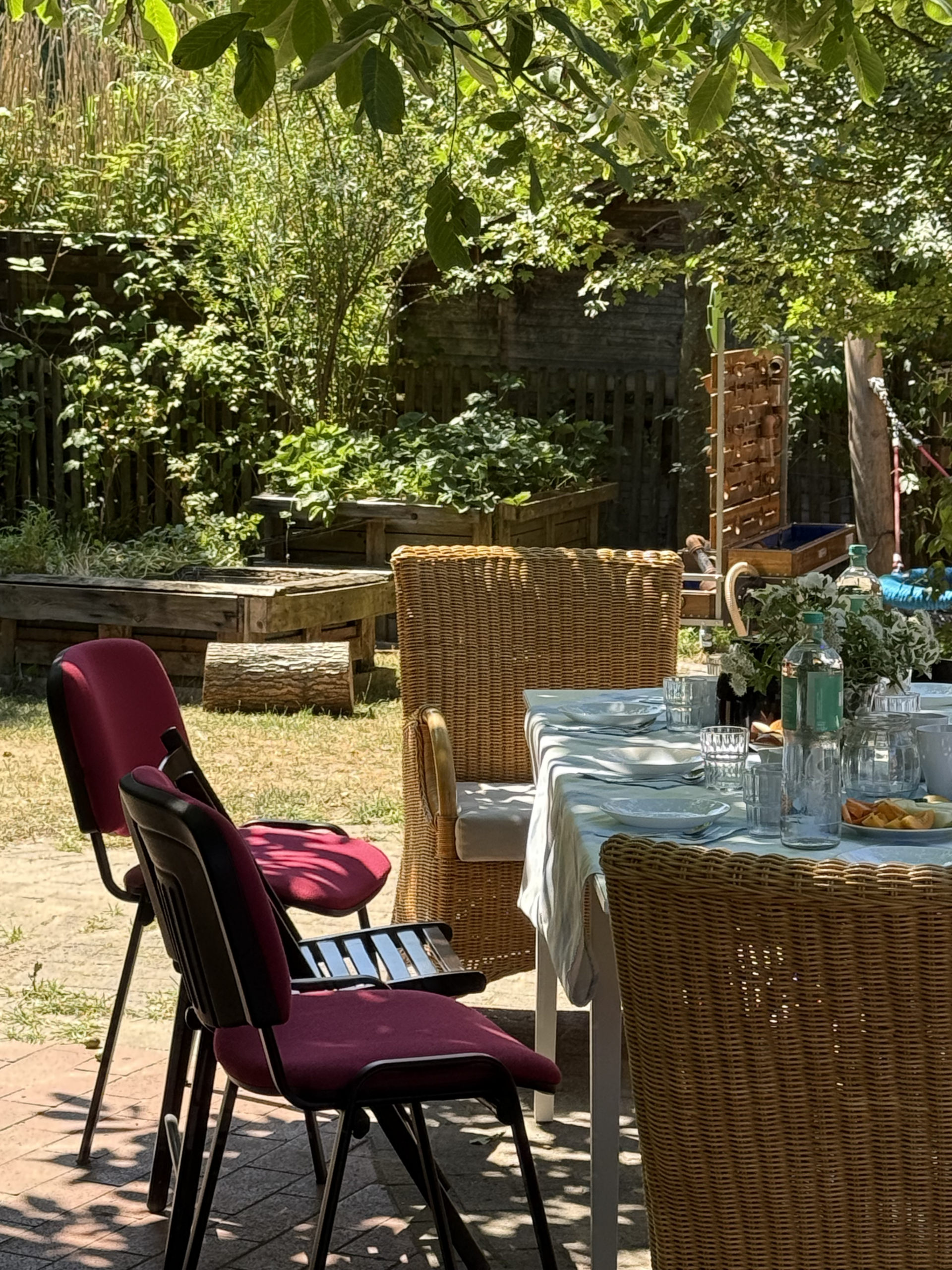 Kita-Garten mit Hochbeet und Gartentisch im Schatten